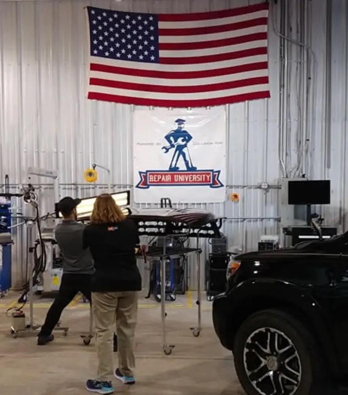 Mike Dorst performing paintless dent repair on a vehicle panel in a workshop